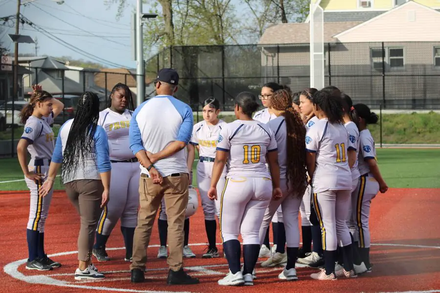 Coach talking with a girls softball team on the field